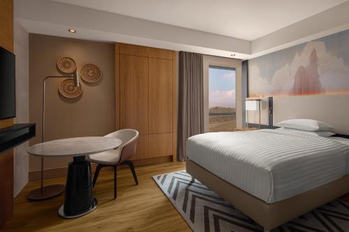 a bedroom with a bed and a table and a desk at Cappadocia Marriott Hotel in Nevsehir