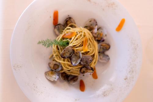 a plate of pasta with mushrooms and carrots at Q Resort in Marina di Sorso