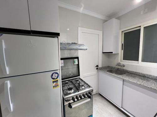 Il comprend une petite cuisine équipée d'un réfrigérateur et d'une cuisinière. dans l'établissement Property sisters, Elite garden view, Madinaty B6, au Caire