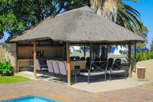 a gazebo with chairs and a table with a roof at Glen Rest Country Lodge in Midrand