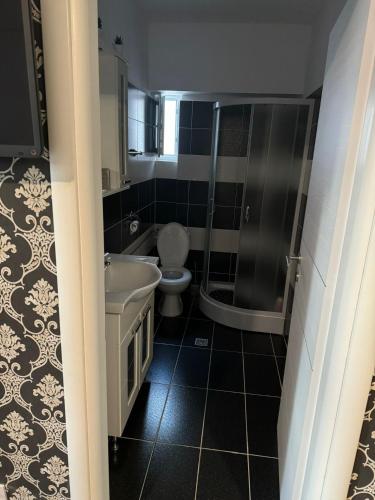 a bathroom with a tub and a toilet and a sink at Paula in Curtea de Argeş