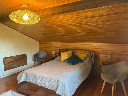 a bedroom with a bed and two chairs at Sur les hauteurs de Labroquère in Labroquère