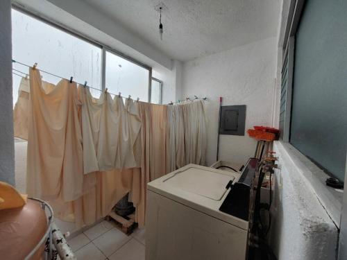 a bathroom with a washing machine and a window at Costa Azul a 100 mts playa in Acapulco