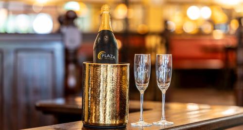 a bottle of champagne in a can next to two wine glasses at PLAZA INN Chemnitz in Chemnitz