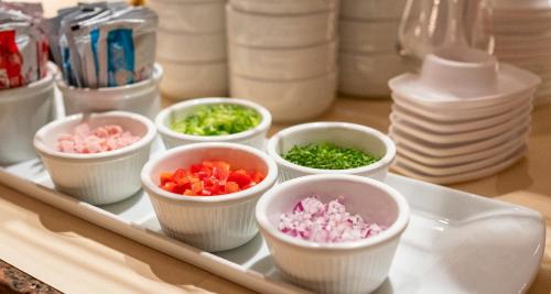 a tray with bowls of chopped vegetables on a table at PLAZA INN Chemnitz in Chemnitz