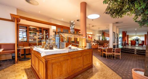a restaurant with a counter in a room at PLAZA INN Chemnitz in Chemnitz
