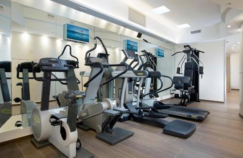 a gym with several treadmills and cardio machines at Hotel Feldberg in Riccione