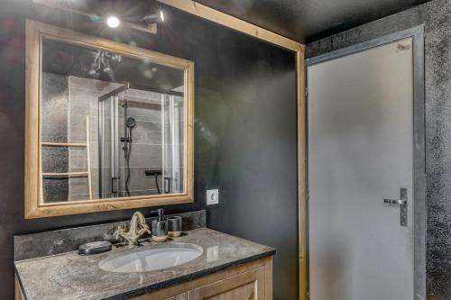 une salle de bain avec un lavabo et un miroir dans l'établissement Appartement Chez Albert situé 25KM Chamonix, à Saint-Gervais-les-Bains