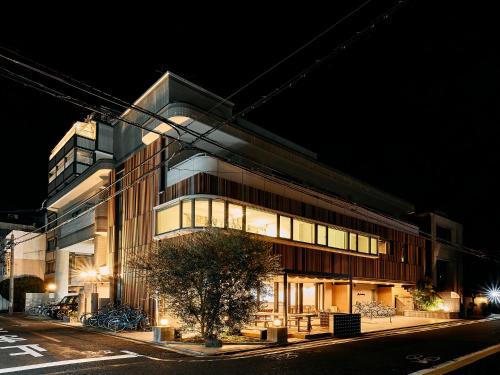 a building on a city street at night at Kyoto Guesthouse HIVE in Kyoto