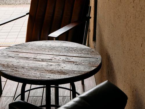 a wooden table and two chairs sitting next to a wall at Kyoto Guesthouse HIVE in Kyoto