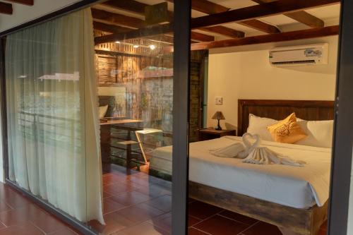a bedroom with a bed and a sliding glass door at D Banlieue Homestay And Coffee TP Kon Tum in Kon Tum
