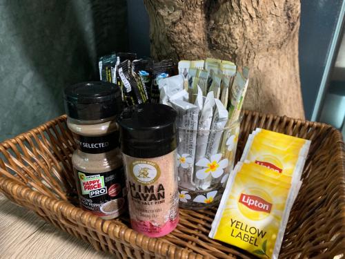 a basket filled with condiments and condiments at Wooden House,Rustic charm in quiet area in Ban Khlong Chi Lat