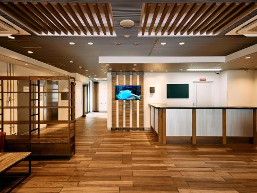 a lobby of a building with a table and a tv at Kyoto Guesthouse HIVE in Kyoto