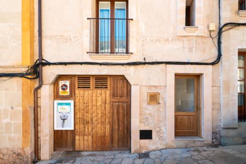a building with a wooden door and two windows at Can 32 Apartamento 1 habitación in Pollença