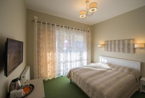 a bedroom with a bed and a large window at Vila Levita in Palanga