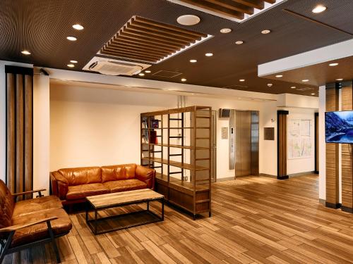 a lobby with a leather couch and a table at Kyoto Guesthouse HIVE in Kyoto