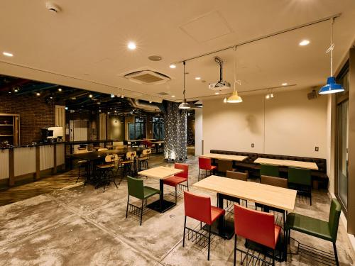 a restaurant with tables and chairs in a room at Kyoto Guesthouse HIVE in Kyoto