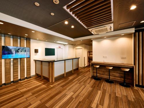 a large room with a bar and a projection screen at Kyoto Guesthouse HIVE in Kyoto