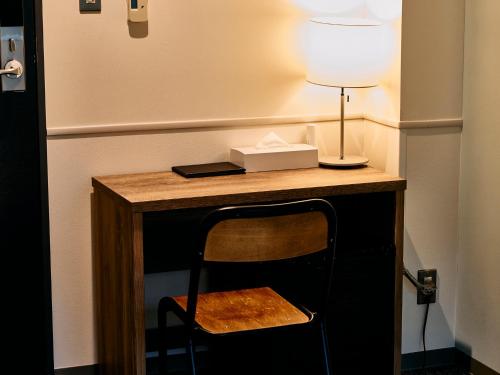 a desk with a chair and a lamp on it at Kyoto Guesthouse HIVE in Kyoto