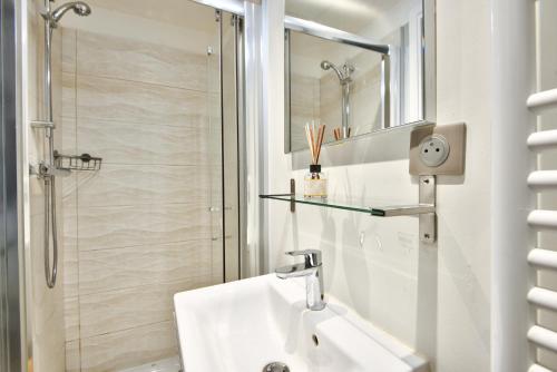 une salle de bain blanche avec un lavabo et une douche dans l'établissement Studio avec grande terrasse YourHostHelper, à Villefranche-sur-Mer