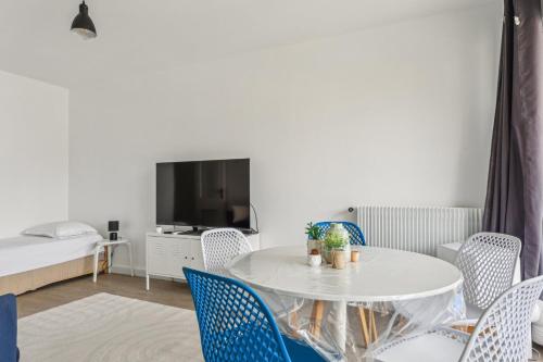 un salon avec une table et des chaises blanches dans l'établissement Le Familial - Charming apartment in Paris, à Paris