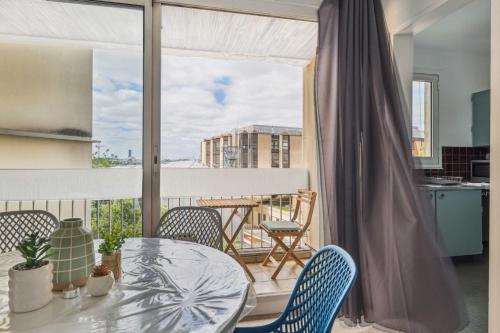 un balcon avec une table, des chaises et une fenêtre dans l'établissement Le Familial - Charming apartment in Paris, à Paris