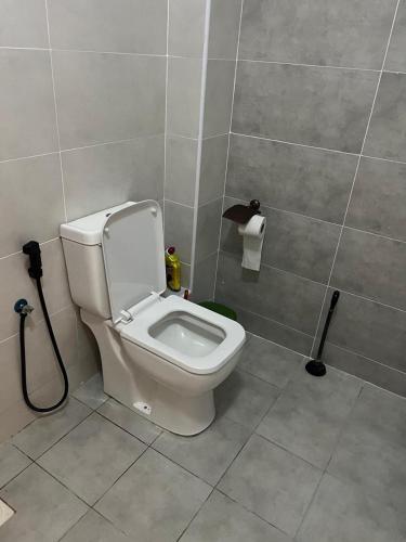 a bathroom with a white toilet in a stall at Exquisite 2BR apartment Nyali with pool,Ac, washing machine, hot water and near Mall in Mombasa