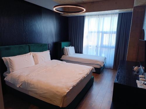 a hotel room with two beds and a window at Toka Hotel Restaurant in Pogradec
