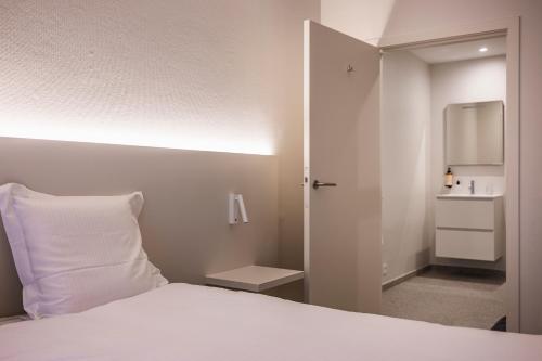 a bedroom with a white bed with a white pillow at House 22 longstay in Kortrijk