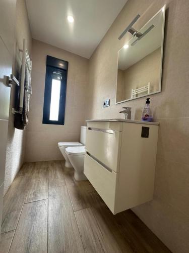 a bathroom with a sink and a toilet and a mirror at Chalet independiente en zona residencial rural con piscina privada in Jaén