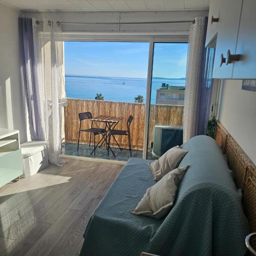 une chambre avec un lit et une vue sur l'océan dans l'établissement Studio 2 personnes Vue Mer Climatisé Linge Maison, au Lavandou