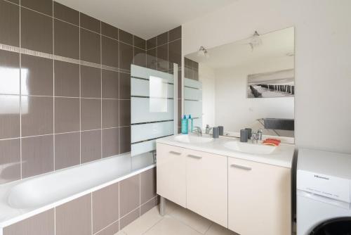 La salle de bains est pourvue de 2 lavabos, d'une baignoire et d'une baignoire. dans l'établissement Maison 8 pers à 15min à pied de la plage avec jardin, à Pornic