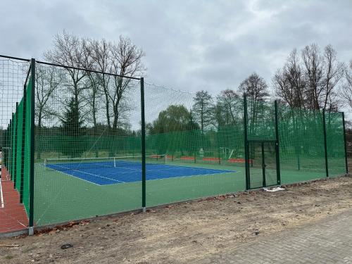 a tennis court with a net on a tennis court at Apartamenty Rycerskie in Inowłódz