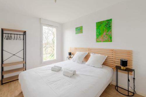 - une chambre avec un grand lit blanc et des oreillers blancs dans l'établissement Maison 8 pers à 15min à pied de la plage avec jardin, à Pornic
