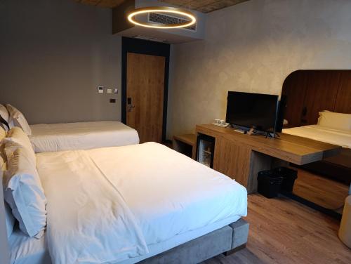 a bedroom with two beds and a desk with a television at Toka Hotel Restaurant in Pogradec