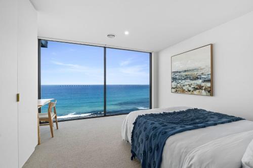 a bedroom with a bed and a view of the ocean at Iluka Lookout in Wye River