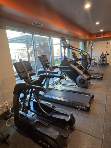 a gym with several tread machines in a room at Downtown Dallas 2bd free parking in Dallas