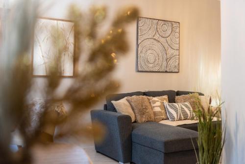a living room with a blue couch with pillows at The Greens premium house - Luxury Apartment in the Heart of the City by Villa Mana Gers in Zakynthos Town