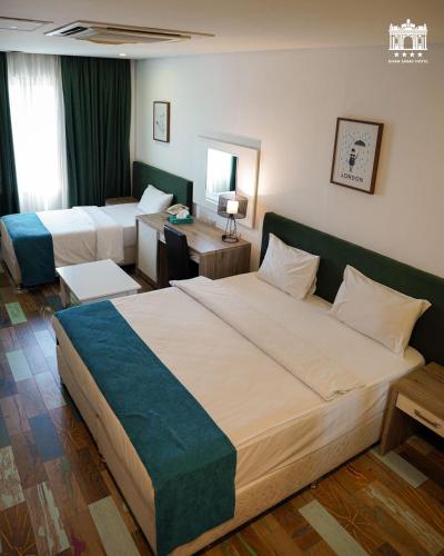 a hotel room with two beds and a desk at Khan Saray in As Sulaymānīyah