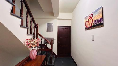 a hallway with a staircase with a vase of flowers at 金門58旅宿 in Hsia-pu-hsia