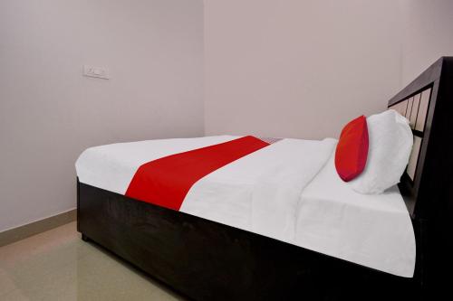 a bedroom with a bed with a red and white blanket at Hotel O Star Rest Hotel in Jaipur