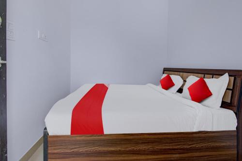 a bedroom with a bed with red and white pillows at Hotel O Star Rest Hotel in Jaipur