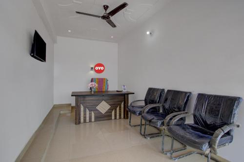 a living room with two chairs and a table and a ceiling fan at Hotel O Star Rest Hotel in Jaipur