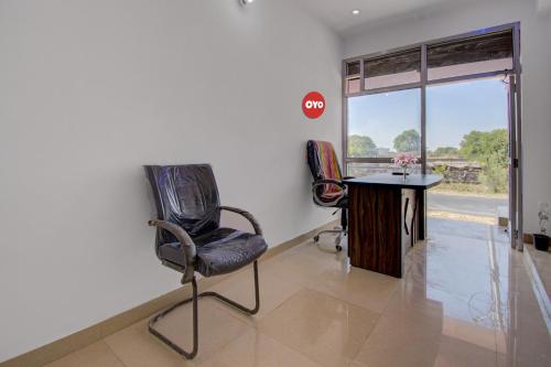 a room with two chairs and a table and a window at Hotel O Star Rest Hotel in Jaipur