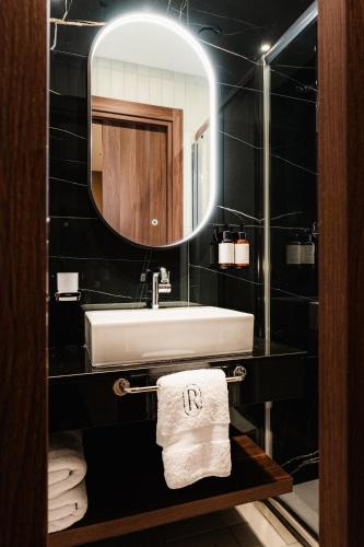 a bathroom with a sink and a mirror at Royale Sainte Hélène Boutique Hotel in Birkirkara