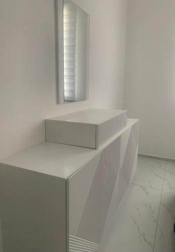a white shelf with a mirror in a white room at B&B Passione Salento in Surbo