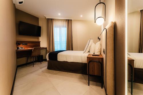 a hotel room with a bed and a desk at Royale Sainte Hélène Boutique Hotel in Birkirkara
