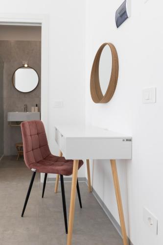 a white desk with a chair and a mirror at Associazione Garage24 Aps Ets in Portoferraio