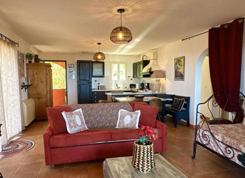 un salon avec un canapé rouge et une cuisine dans l'établissement Villa Catalina, à SantʼAntonino