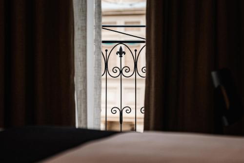 an open door to a balcony with a iron gate at Royale Sainte Hélène Boutique Hotel in Birkirkara